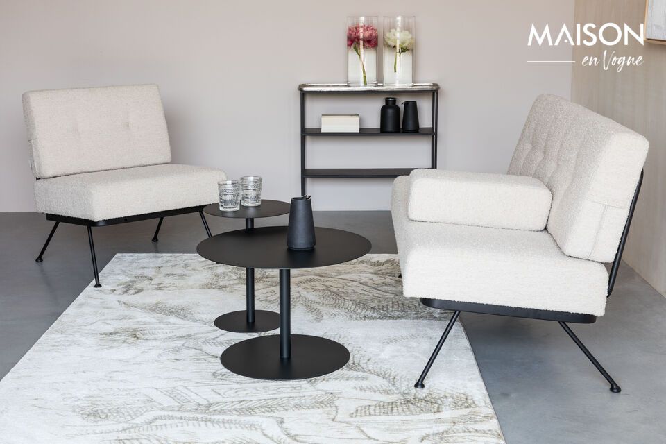 The black metal frame and grid backrest blend harmoniously with the thick seat and curly
