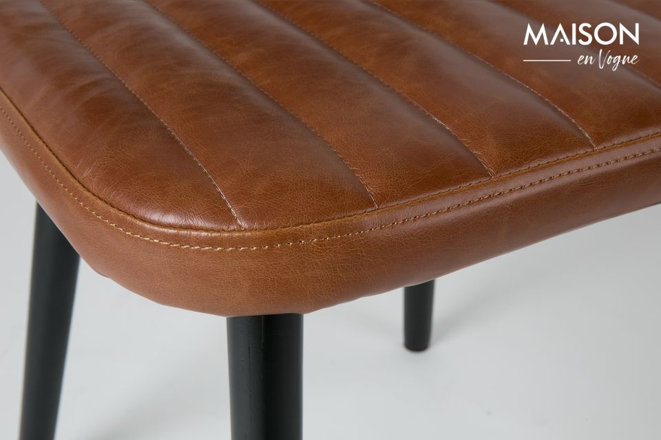 Le design de ce modèle de chaise Jake Worn évoque un style vintage avec le dossier et coussin