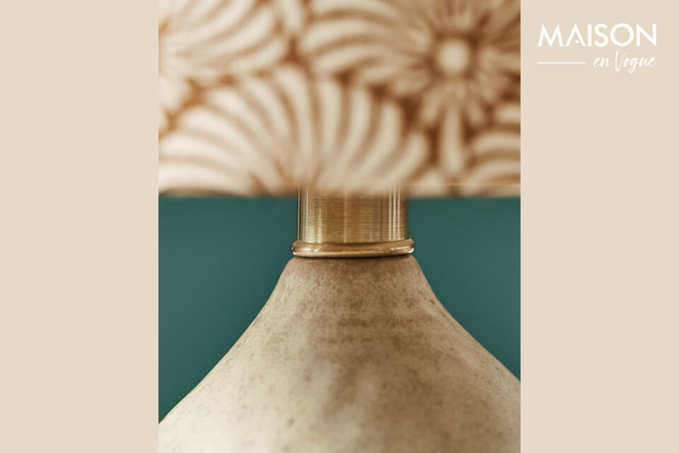 Presenta una base in ceramica color sabbia e un paralume in lino ornato con motivi a ventaglio
