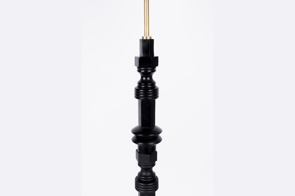 La robusta base della lampada da terra combina legno massiccio di mango e alluminio