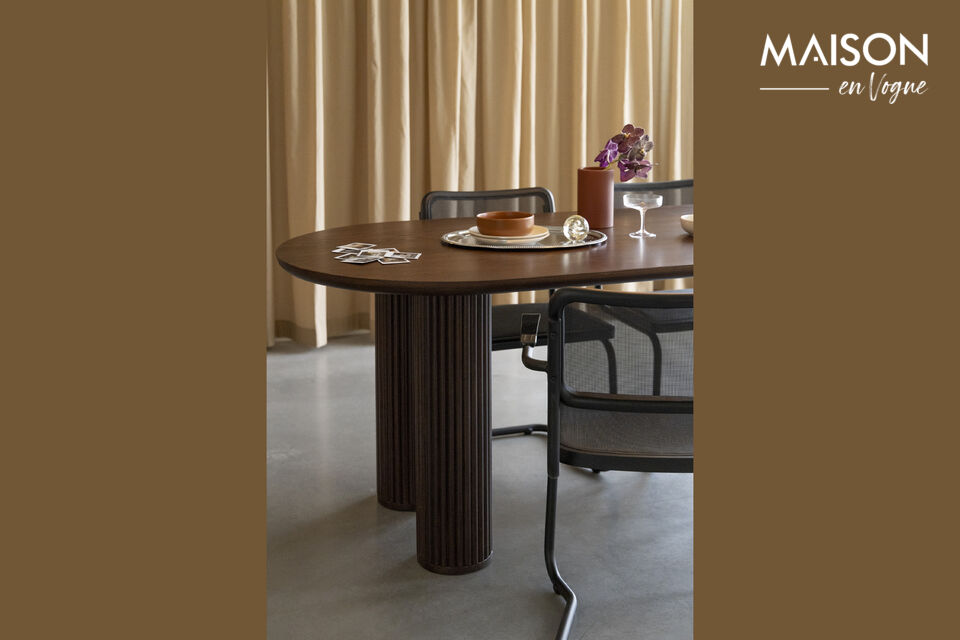 This striking dining table has a large, oval tabletop with rounded edges at the bottom