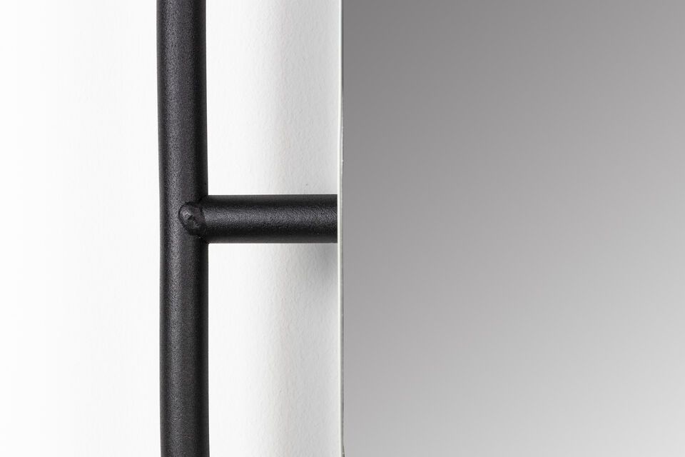 The black steel frame doesn\'t just support the mirror; it also serves as a practical support for