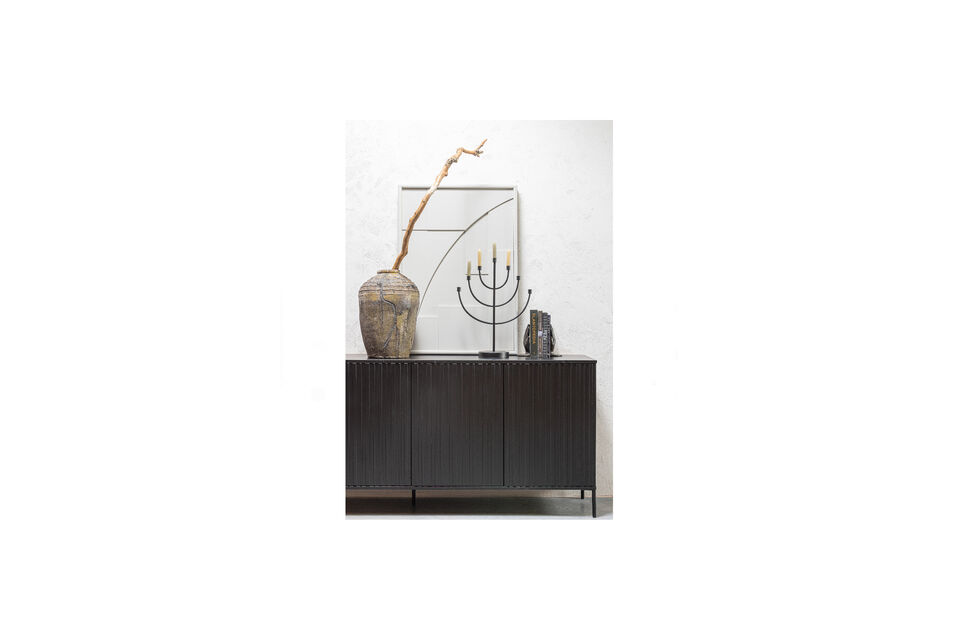 Generous sideboard with graphic relief doors Made of pine wood with black metal base Stylish piece