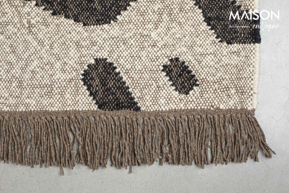 Ses franges élégantes à chaque extrémité et son motif organique ajoutent une touche